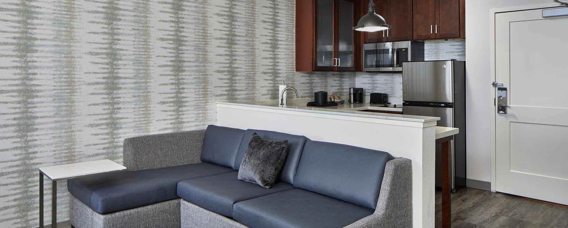 Modern kitchenette with stainless steel appliances and granite countertops